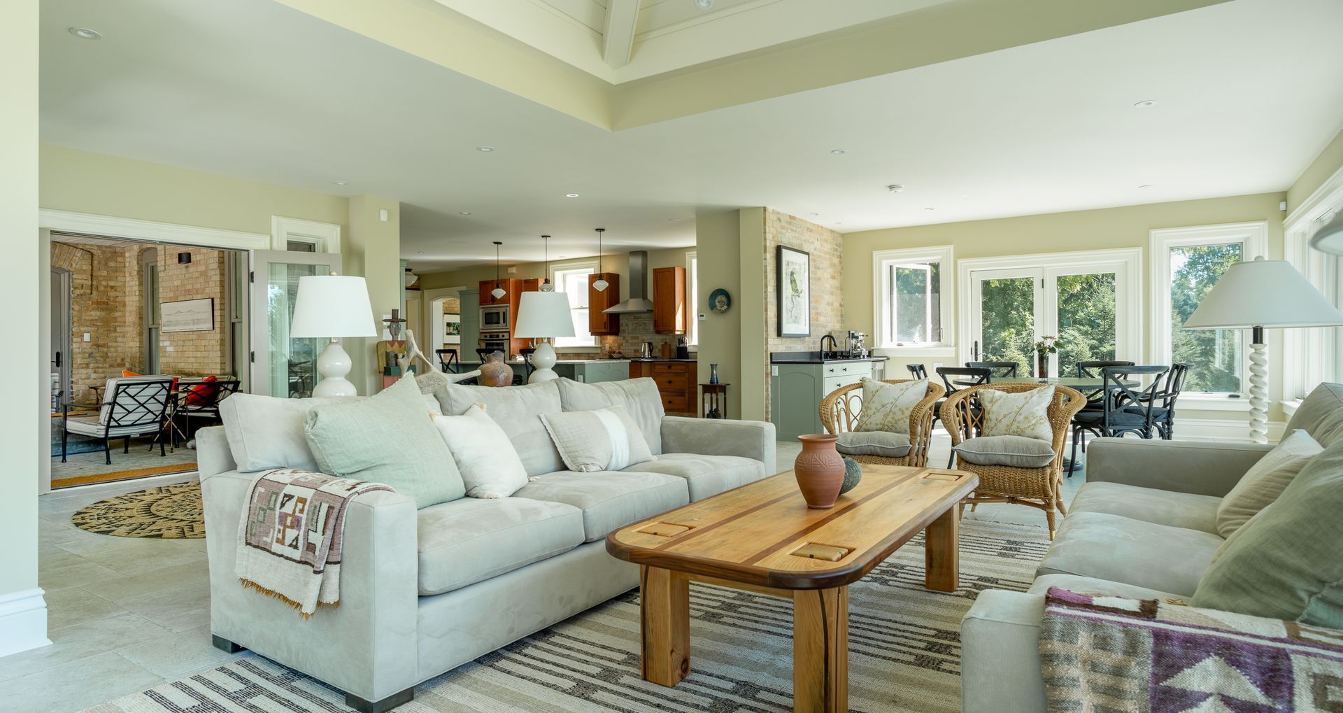 Spacious living room with neutral colors, couches, and a rustic wooden coffee table.