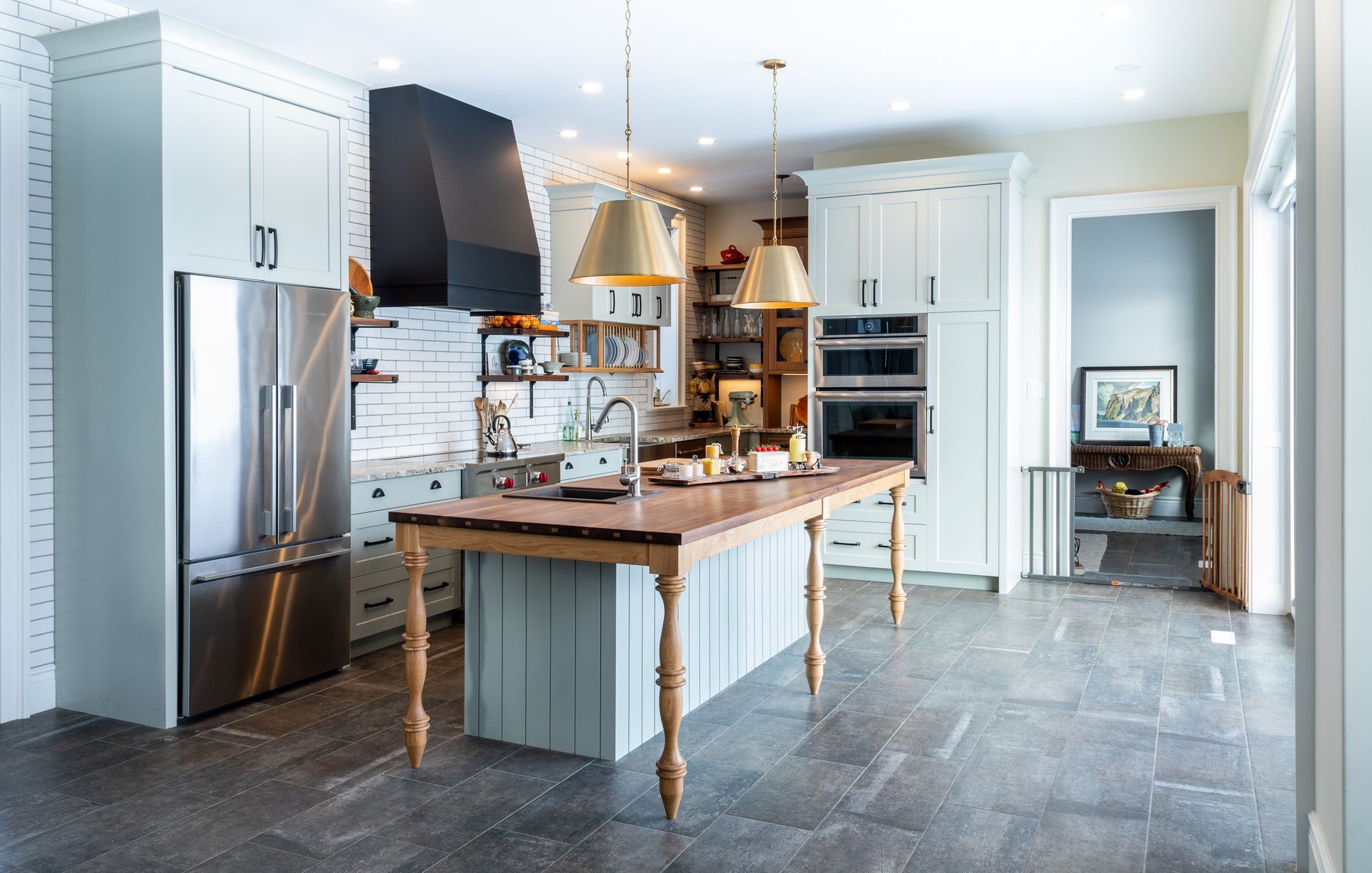 Kitchen with light blue cabinets, stainless steel appliances, and a wooden island.