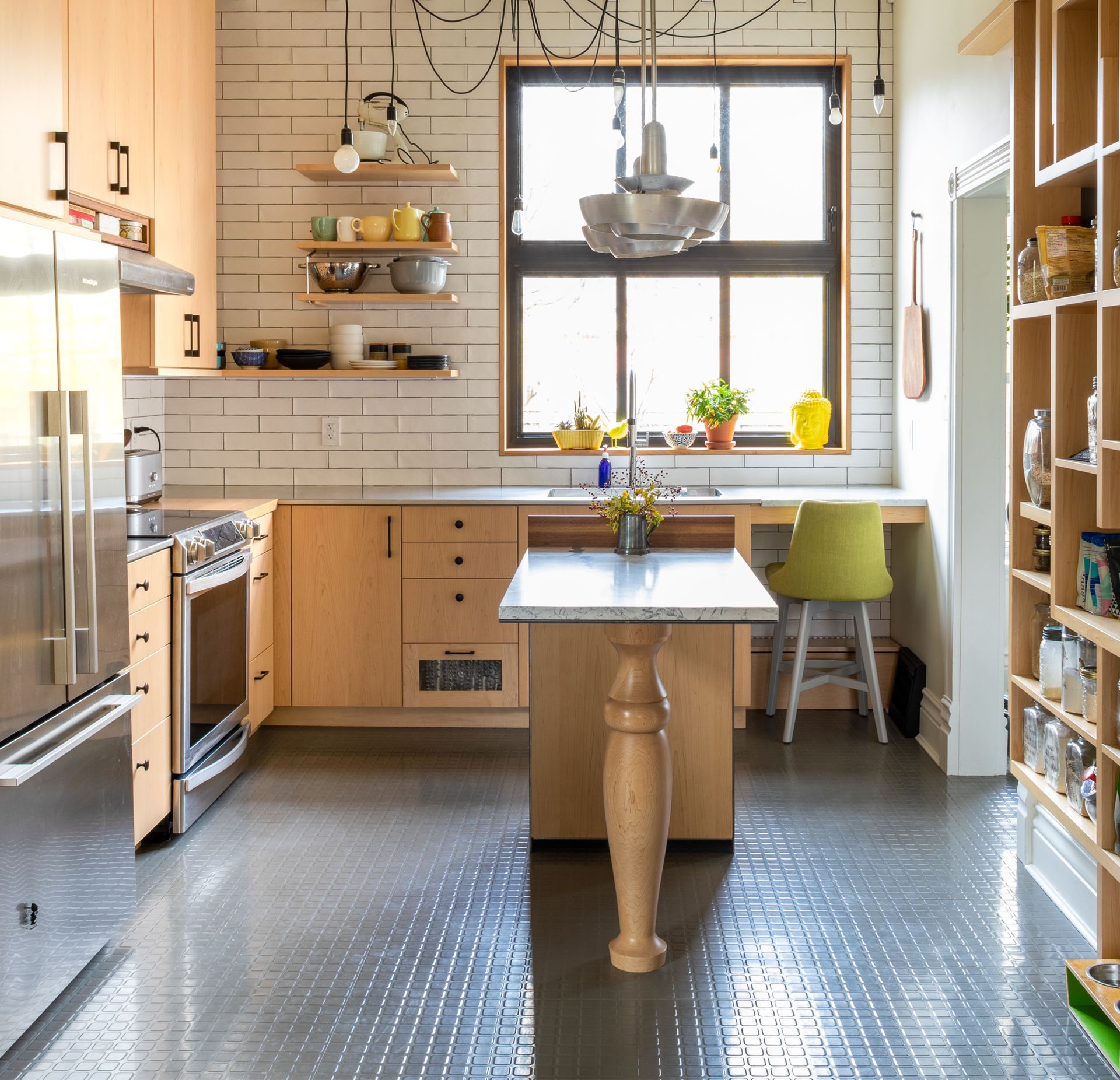 Modern kitchen with stainless steel appliances, butcher block cabinets, and a tile floor.