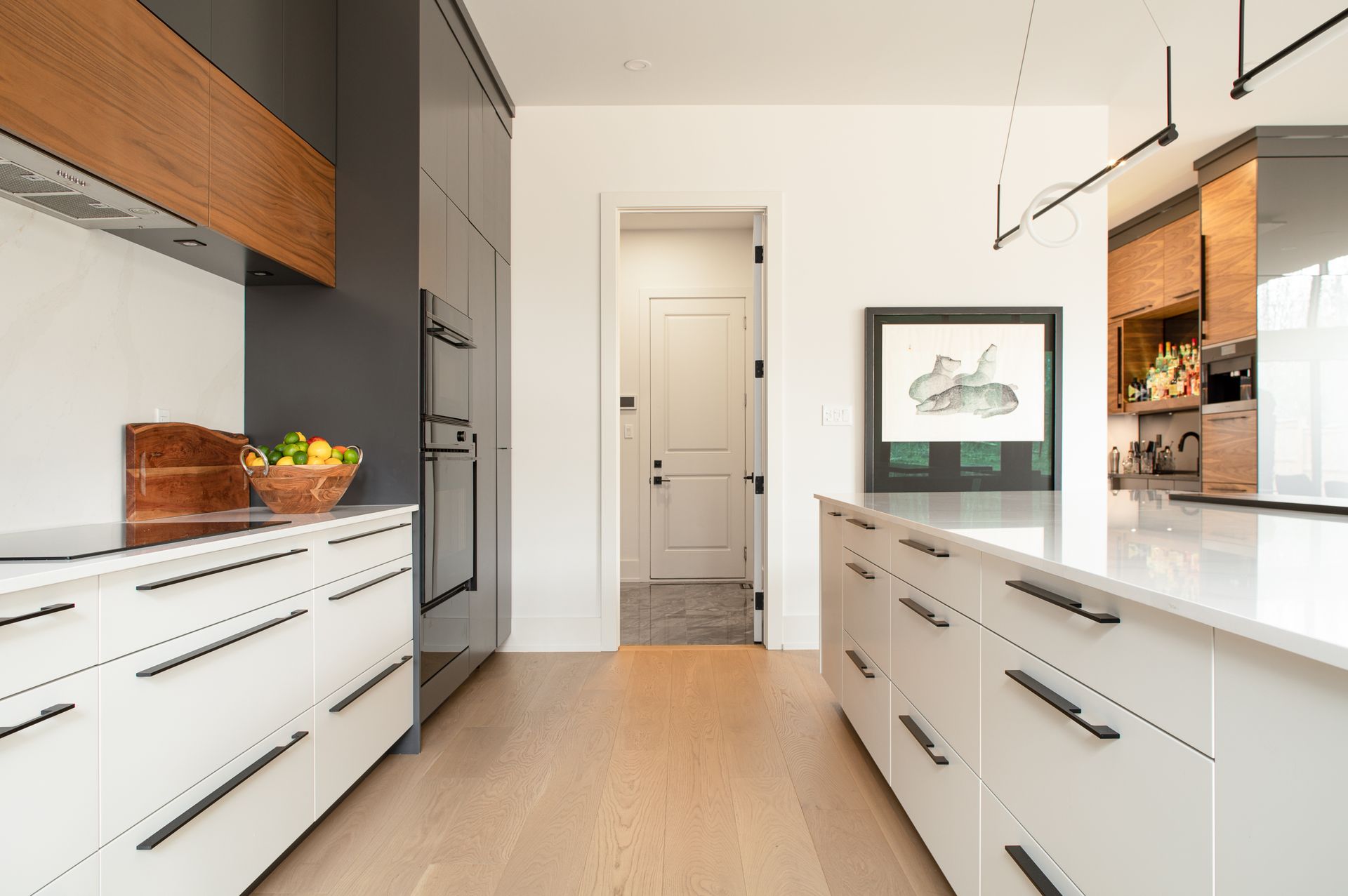 Modern kitchen with white cabinetry, wood accents, and a long island.