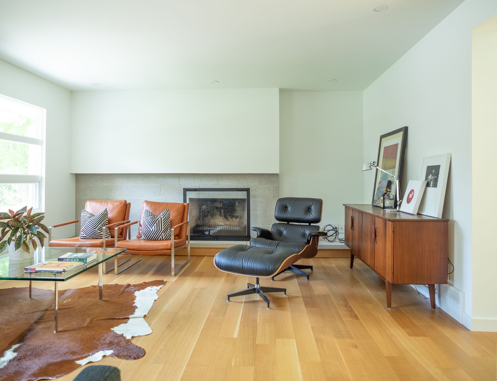 Living room with leather chairs, fireplace, and wood floors.