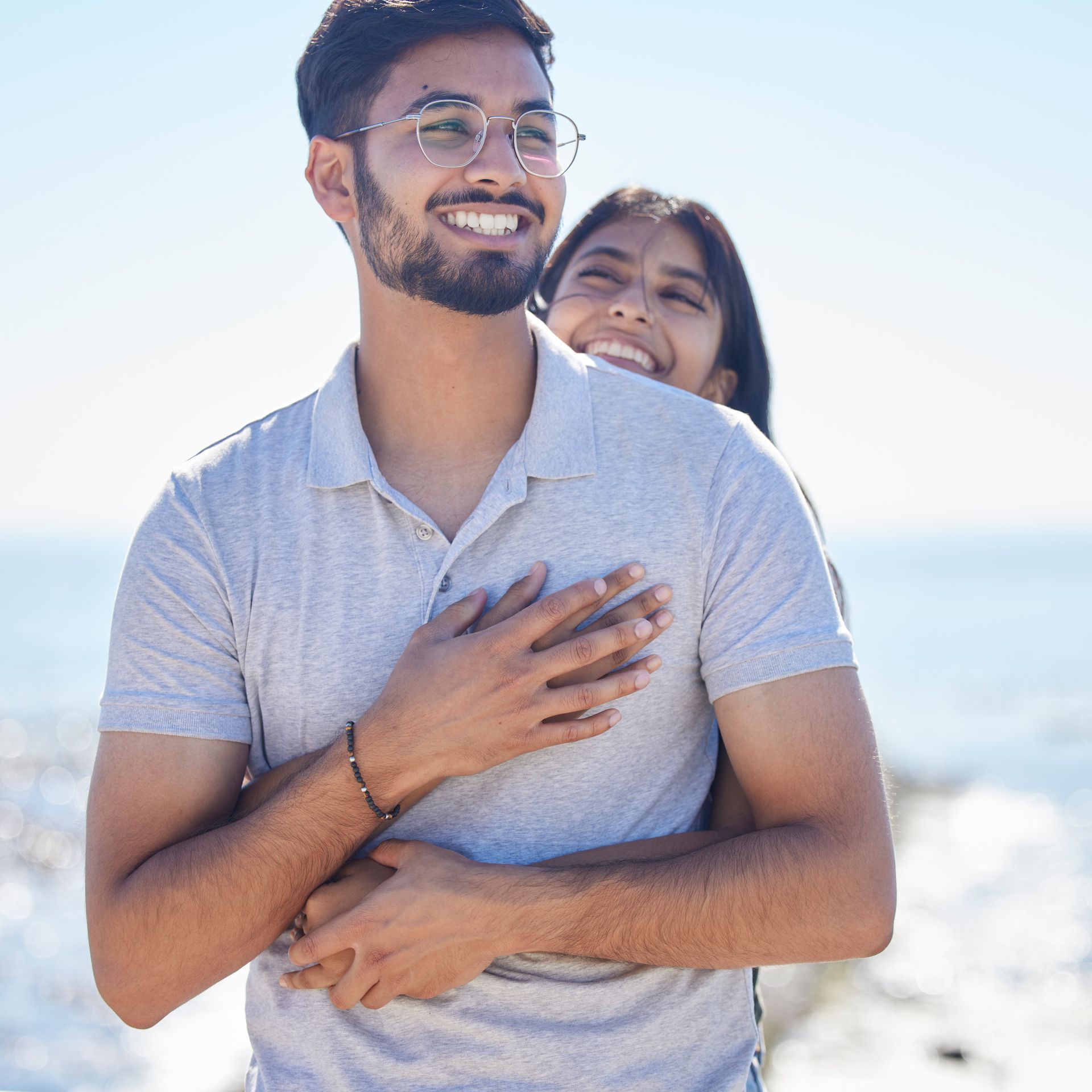 A man and a woman are hugging each other and smiling.