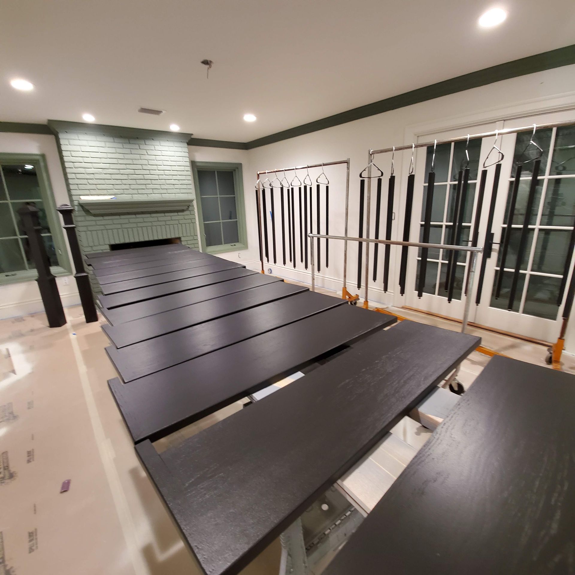 Long black tables in a bright modern room with white walls and large windows Long black tables in a bright modern room with white walls and large windows