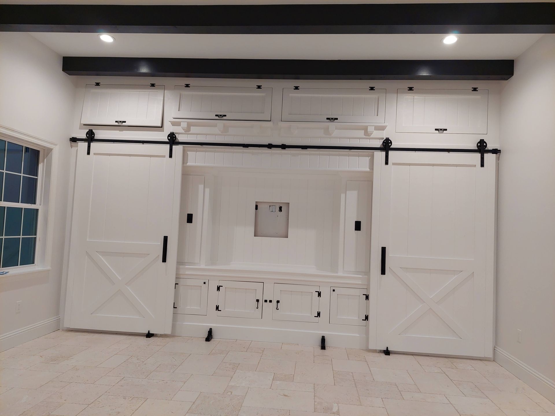 White sliding barn doors with black hardware in a bright interior room