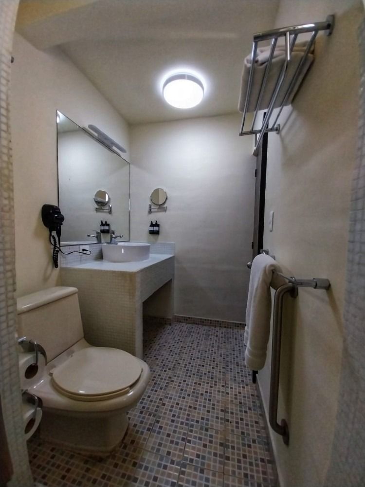 A bathroom with a toilet , sink and mirror