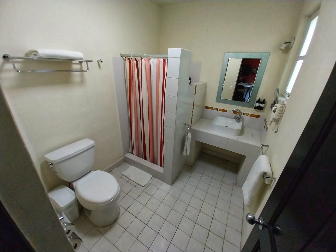 A bathroom with a toilet a sink and a shower