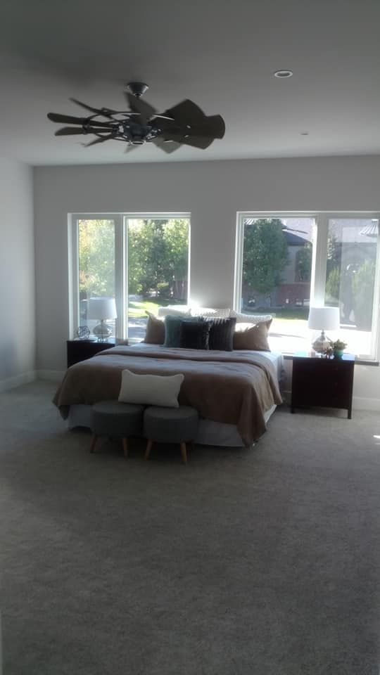 A Bedroom With A Large Bed And A Ceiling Fan | Littleton, CO | All Phase Construction Company LLC