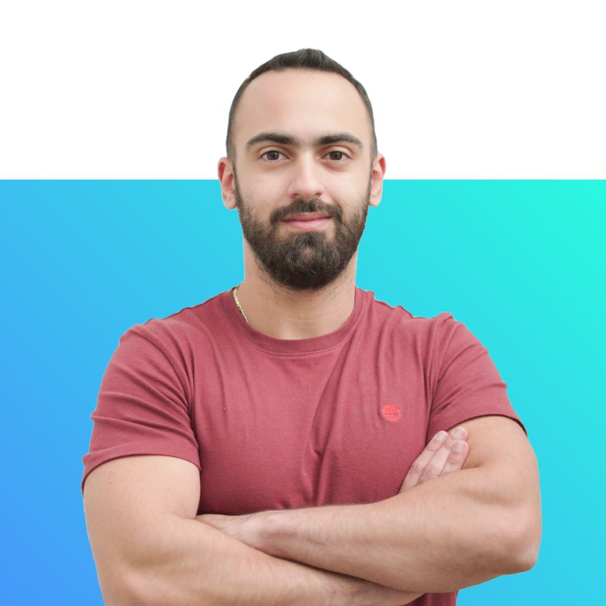 A man with a beard is standing with his arms crossed