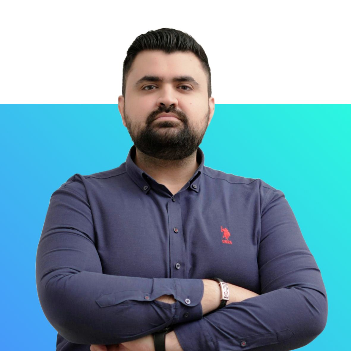 A man with a beard is wearing a blue polo shirt