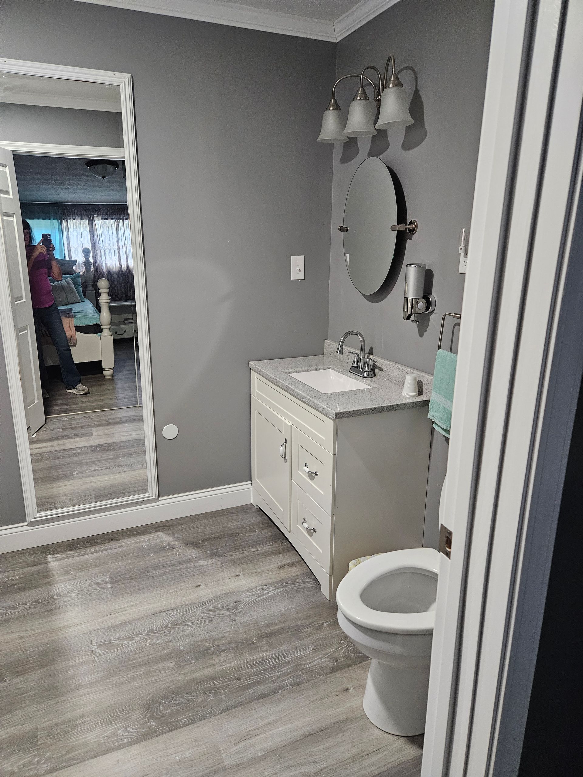 A bathroom with a sink , toilet and mirror.