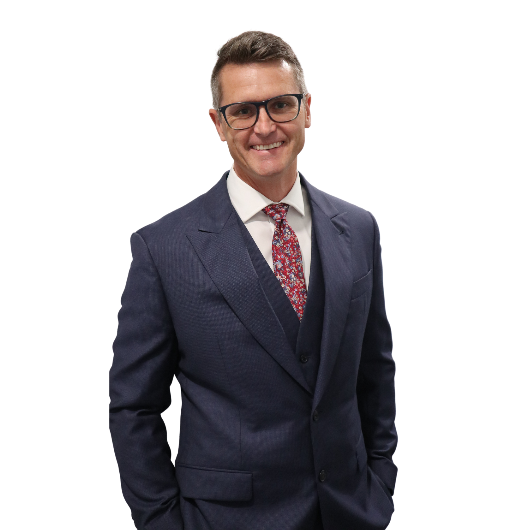 A man in a suit and tie with his hands in his pockets