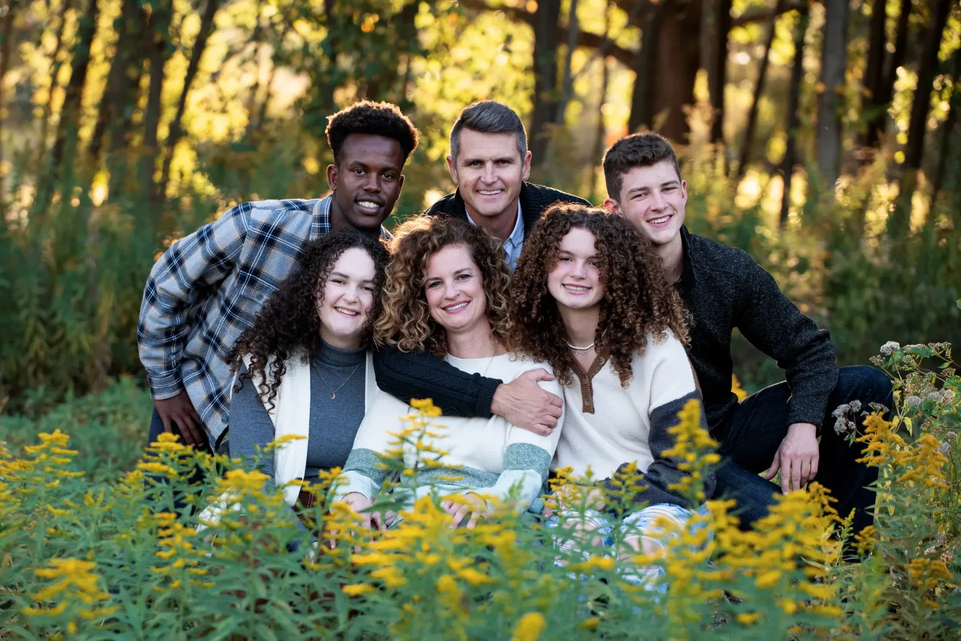 A group of people are posing for a picture in a field of flowers.