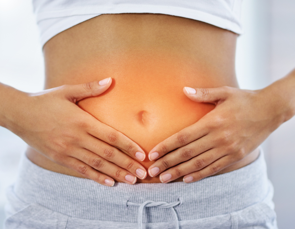 A woman is holding her stomach with her hands.