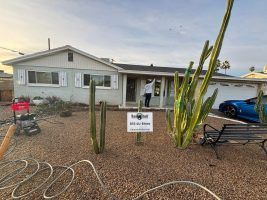 Desert home with gravel yard, cactus plants, and a bench in front of the house