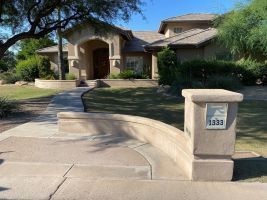 Front view of a suburban house with a curved walkway and stone mailbox marked 1333