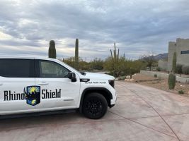 White Rhino Shield truck parked on a driveway under a cloudy desert sky, with cacti in the background