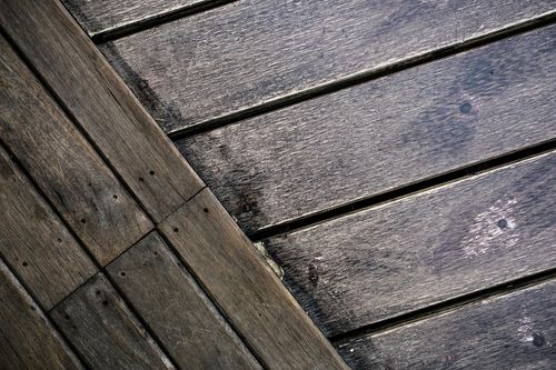 Close-up of weathered gray wooden planks arranged diagonally and horizontally