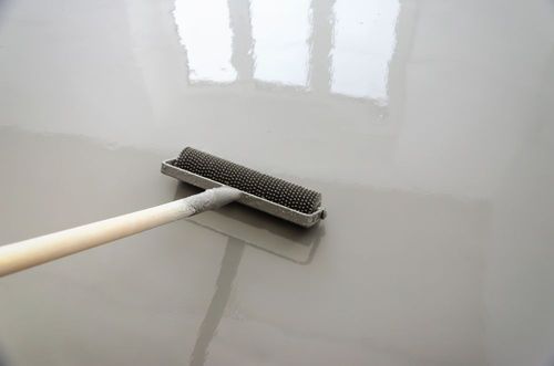 White squeegee on a glossy floor, reflecting a window above