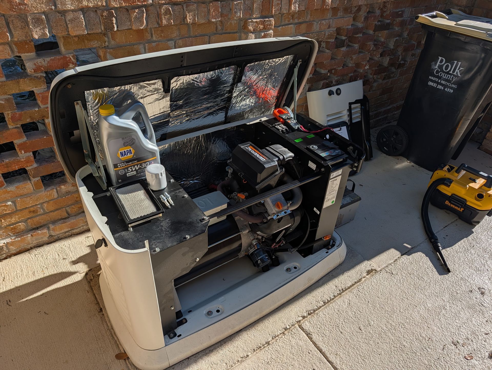 AC unit and generator near a beige house with red roof and green lawn. AC unit and generator near a beige house with red roof and green lawn.