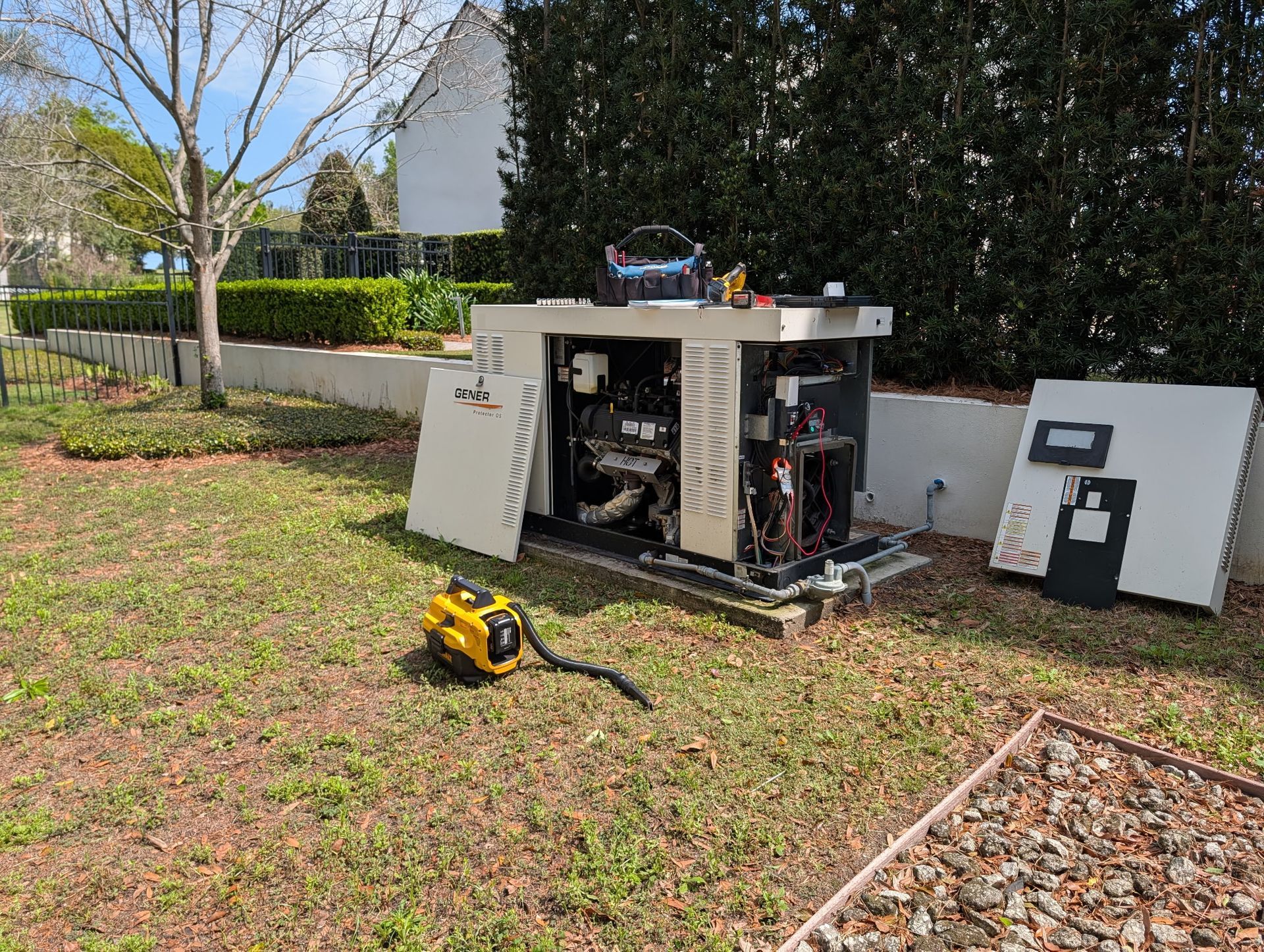 Dark green Briggs & Stratton generator on a concrete pad next to a house, with green grass and foliage. Dark green Briggs & Stratton generator on a concrete pad next to a house, with green grass and foliage.