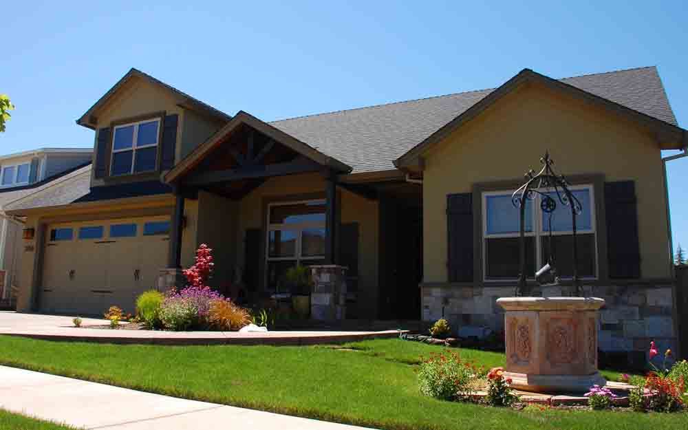 Suburban house with a manicured lawn, front porch, garage, and a decorative fountain in front