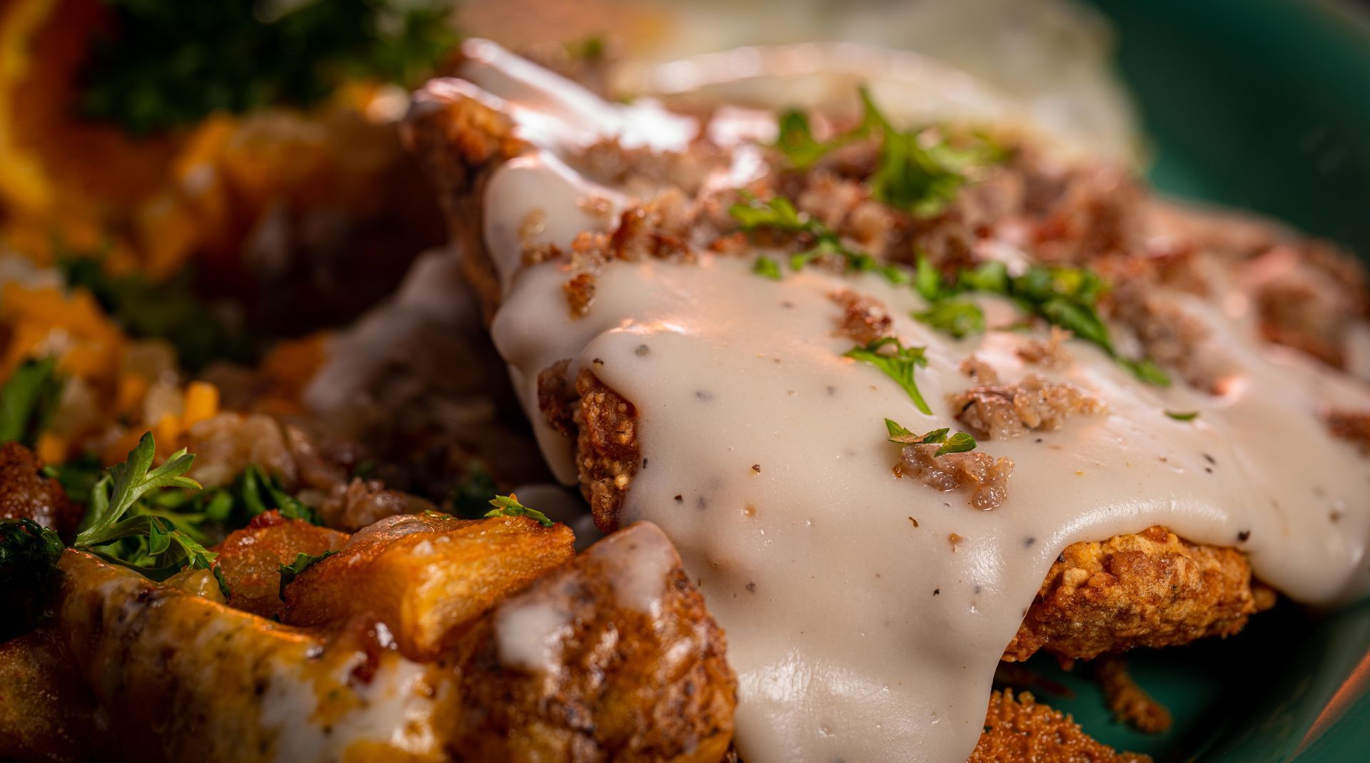 A close up of a plate of food with gravy and potatoes on a table.