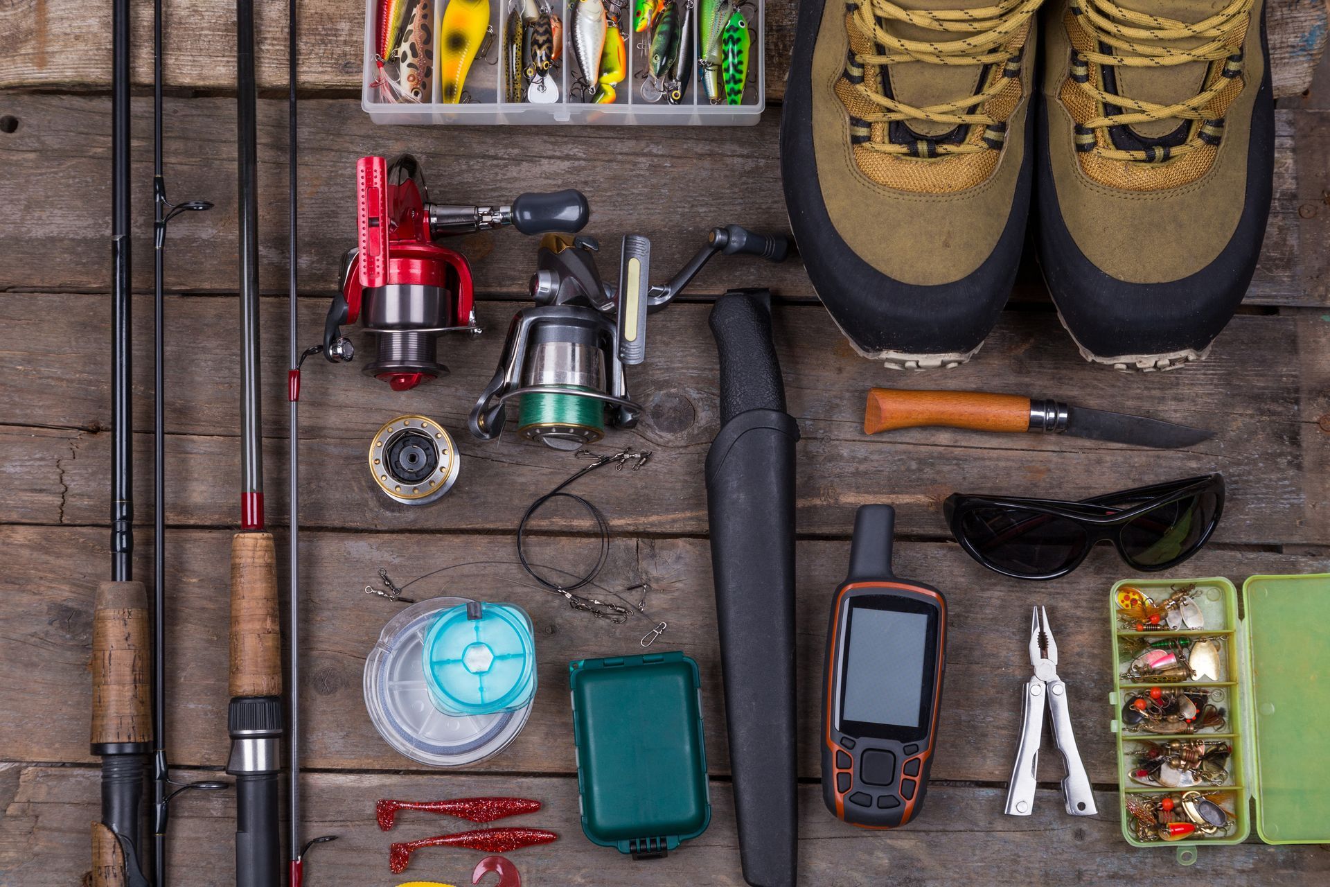 A wooden table topped with a variety of fishing equipment.