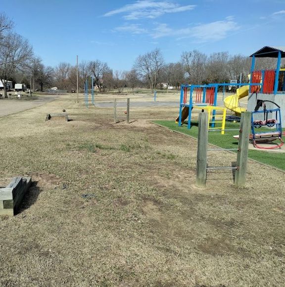 A playground with a yellow slide and red swings