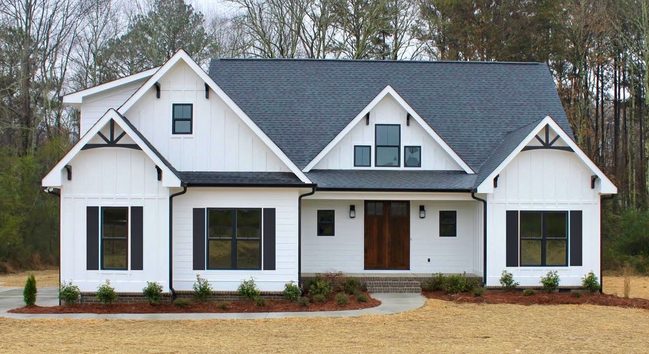 White farmhouse with black trim, windows, and dark roof.