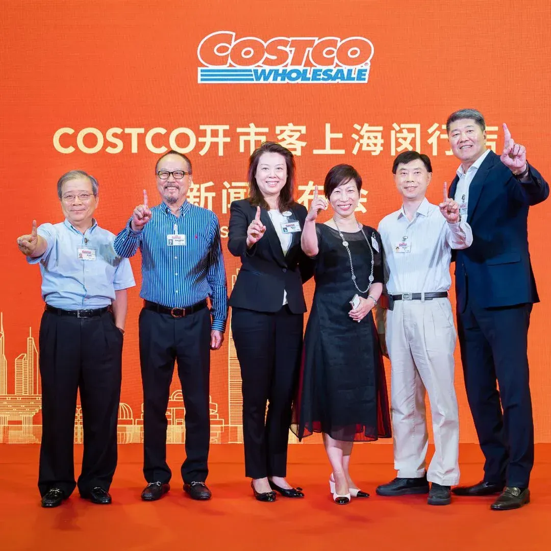 A group of people standing in front of a costco sign