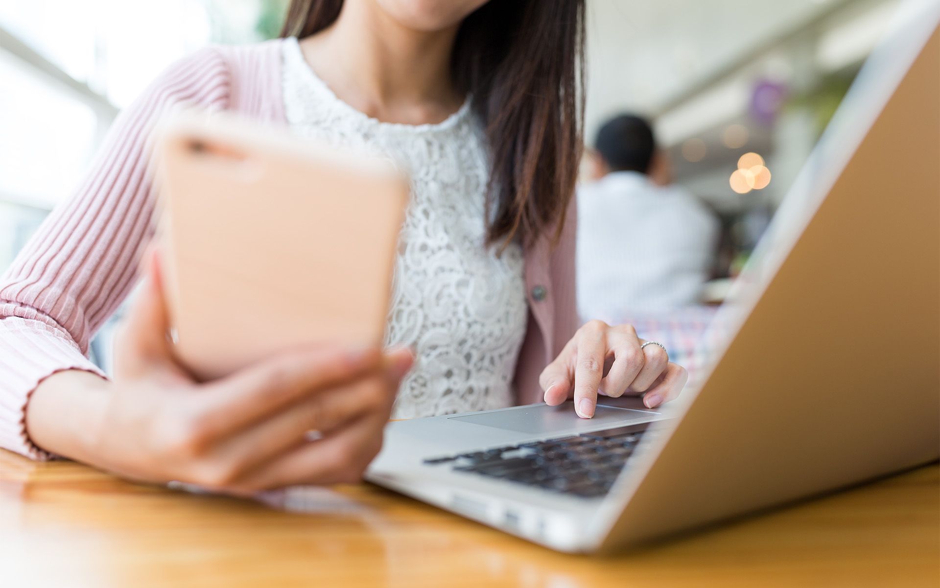 Woman using phone and laptop