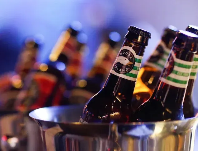 A bunch of beer bottles are in a bucket