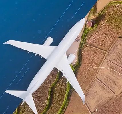 An aerial view of an airplane flying over a body of water