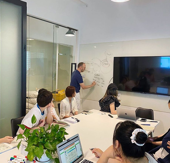 A group of people are sitting around a table in a conference room.
