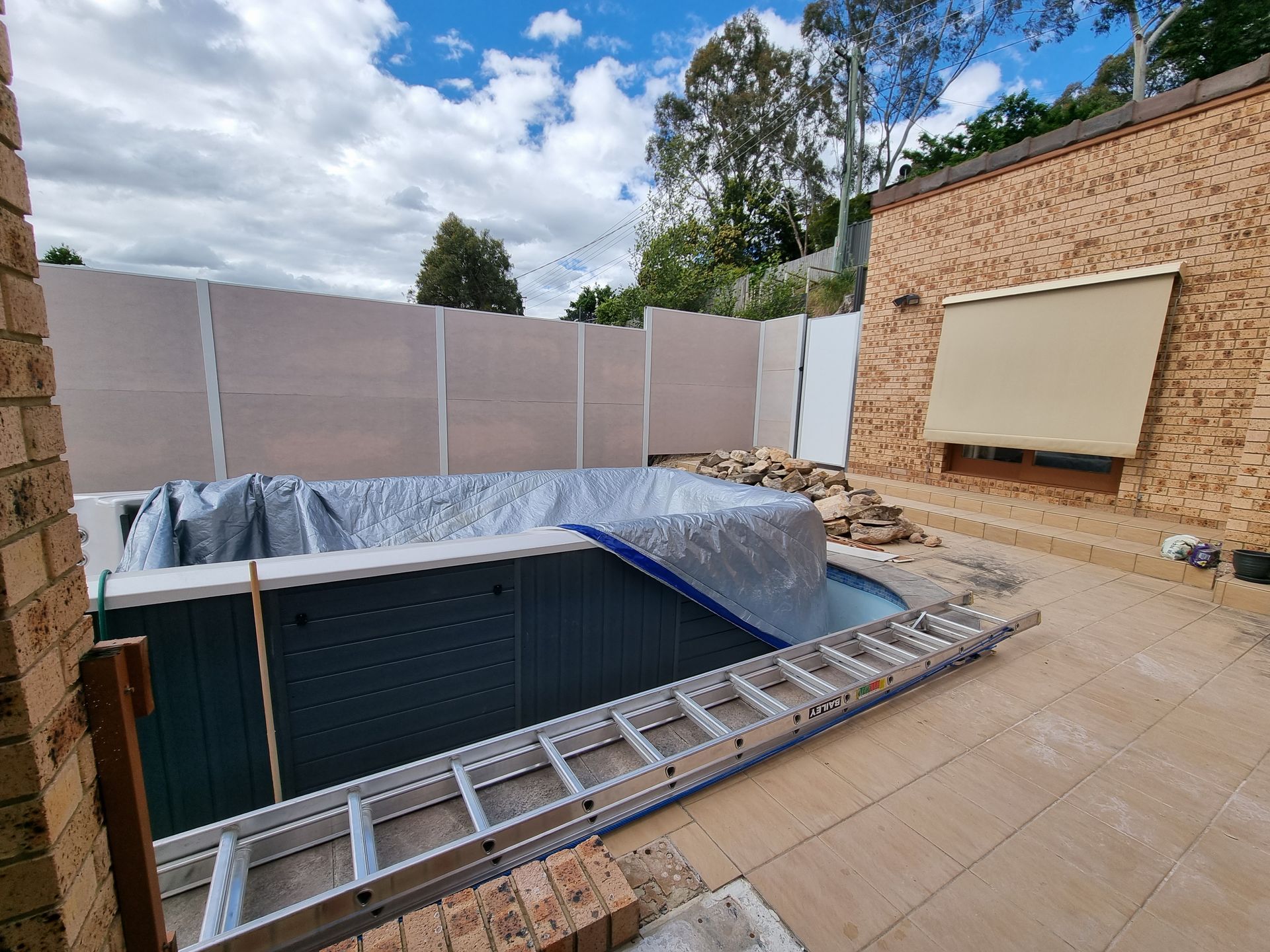 A Brick Building with A Gate in Front of It — GnB Fencing and Excavation in Queanbeyan, NSW