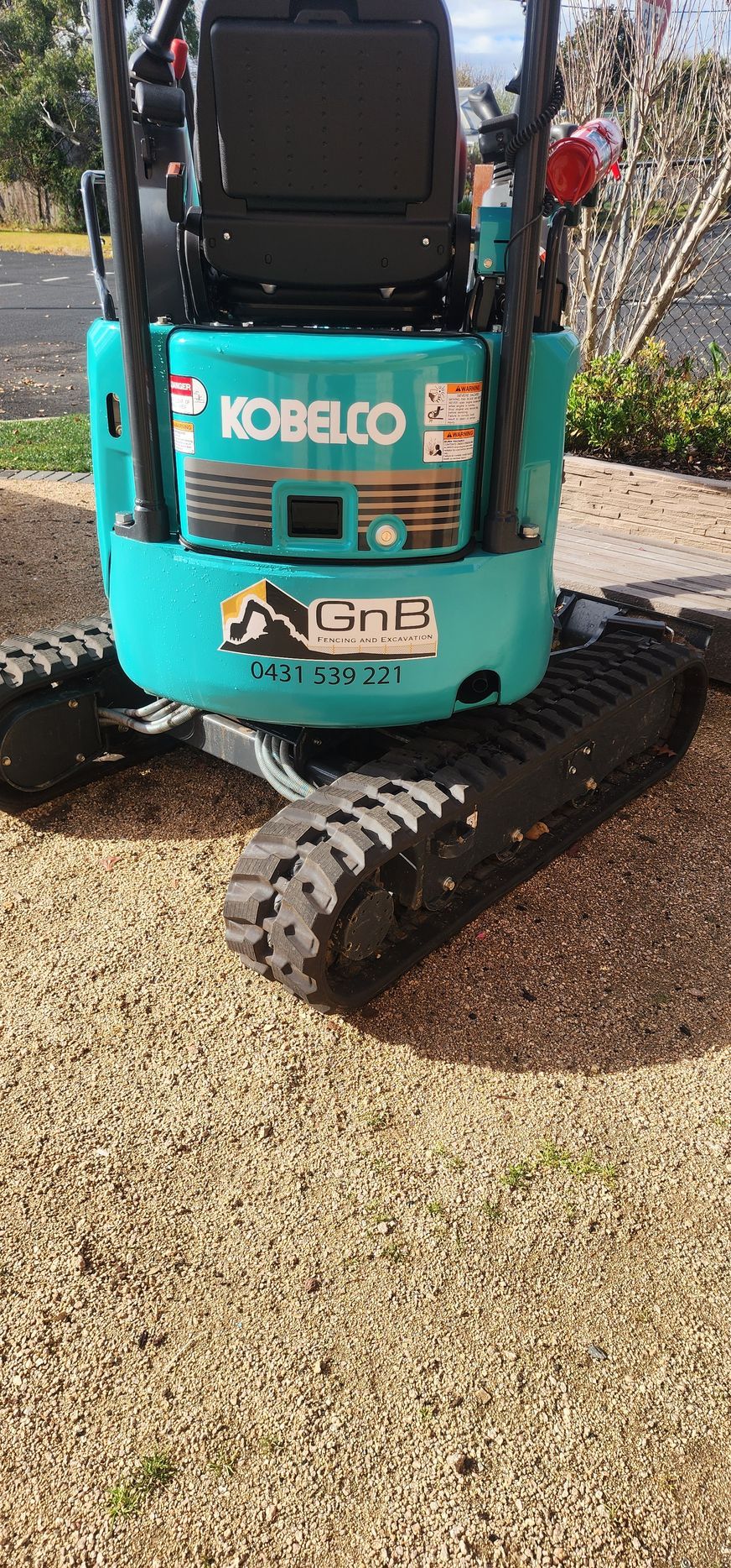 A Black Fence Is Sitting in The Middle of A Dirt Field — GnB Fencing and Excavation in Queanbeyan, NSW