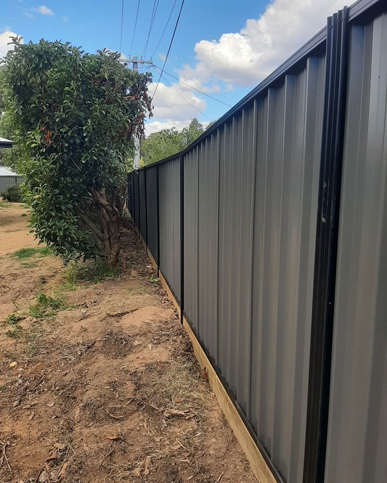 A Fence with A Tree in The Background and A Blue Sky in The Background — GnB Fencing and Excavation in Queanbeyan, NSW