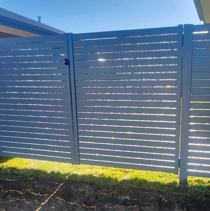 A Blue Fence with A Gate in The Backyard — GnB Fencing and Excavation in Queanbeyan, NSW