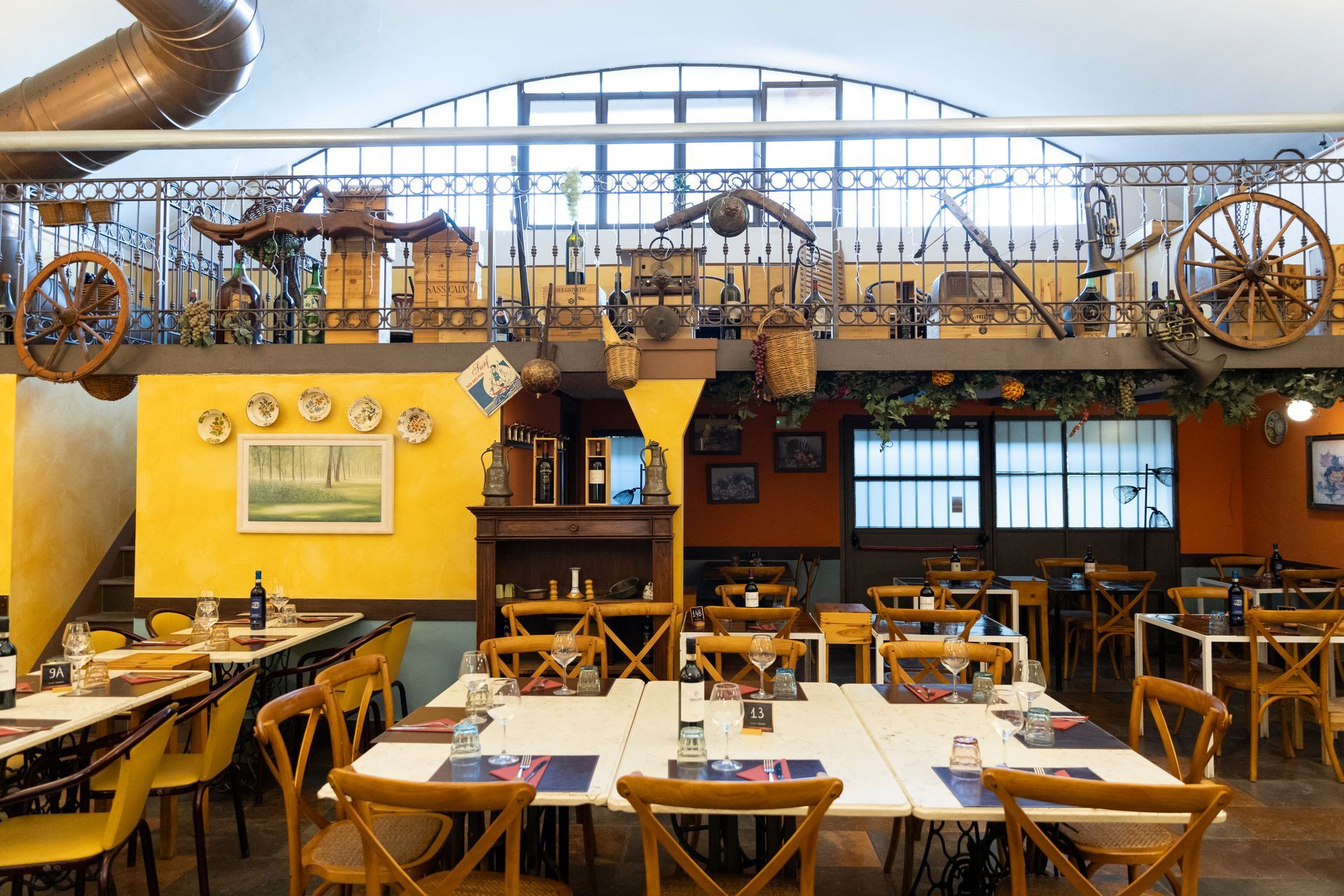 Sala interna rustica dell'osteria con tavoli in legno e luci calde