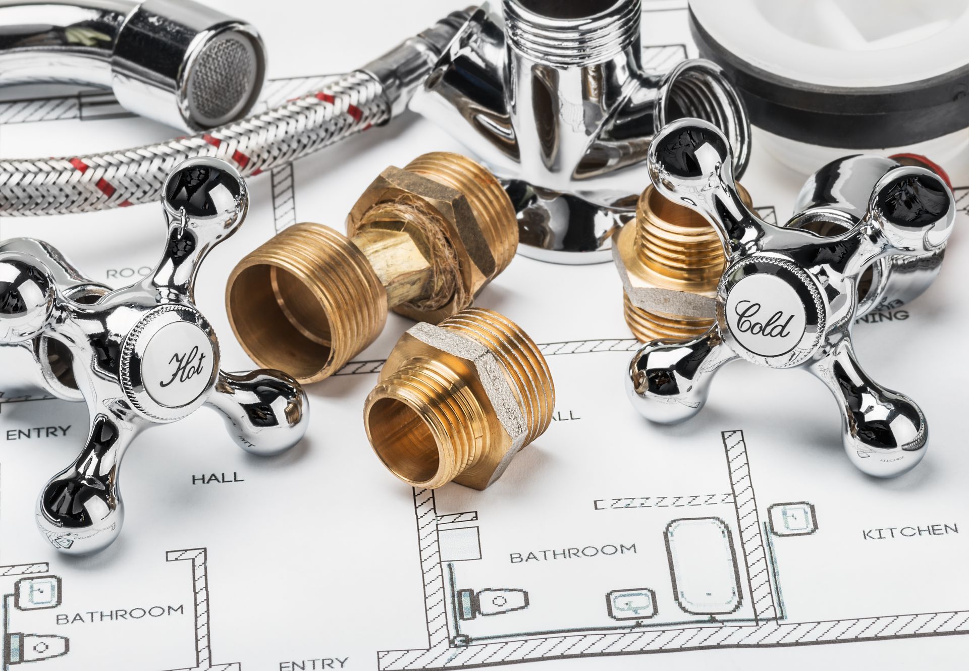 Plumbing fixtures and brass fittings arranged over a bathroom floor plan drawing
