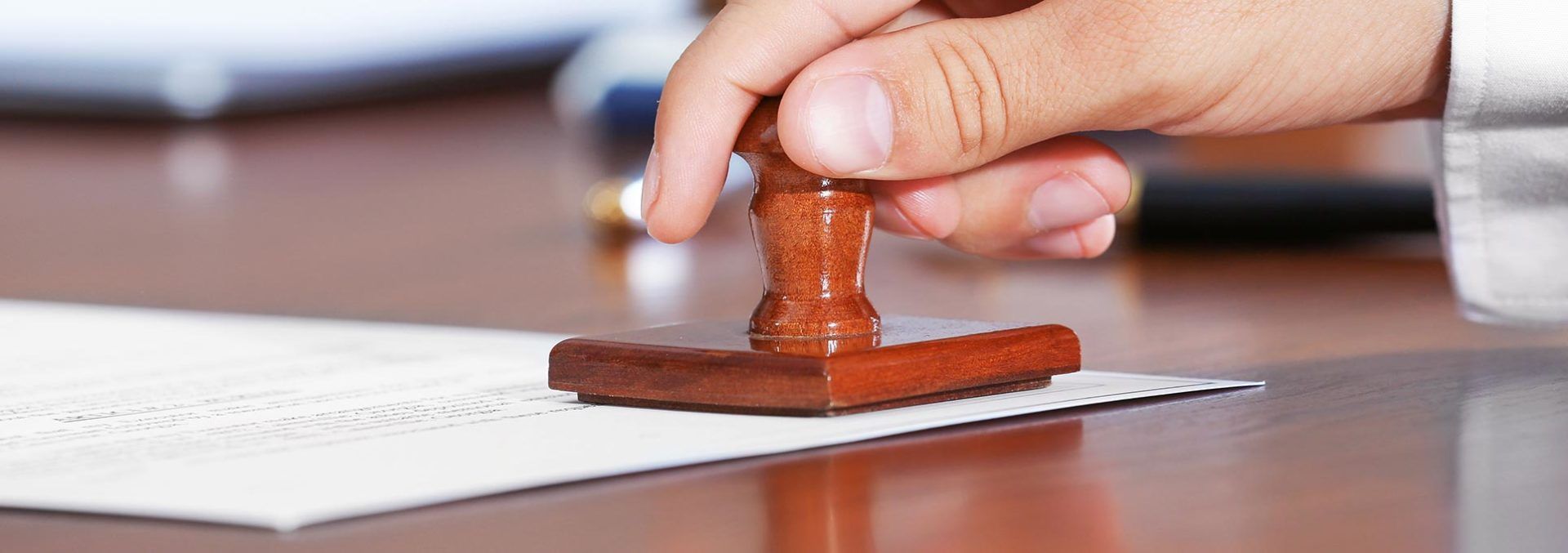 A person is stamping a piece of paper on a table.
