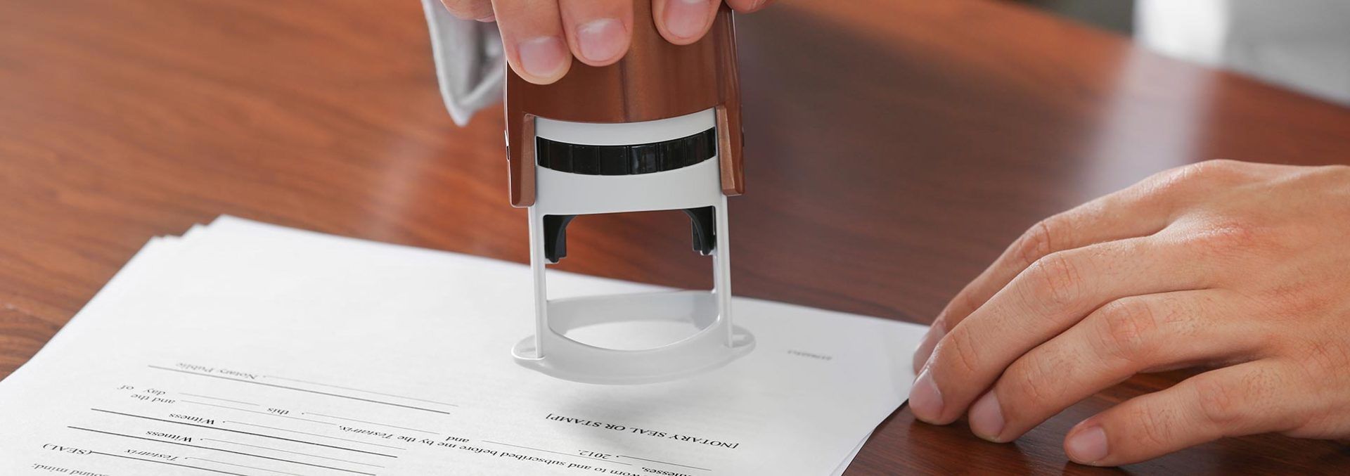A person is putting a stamp on a piece of paper.