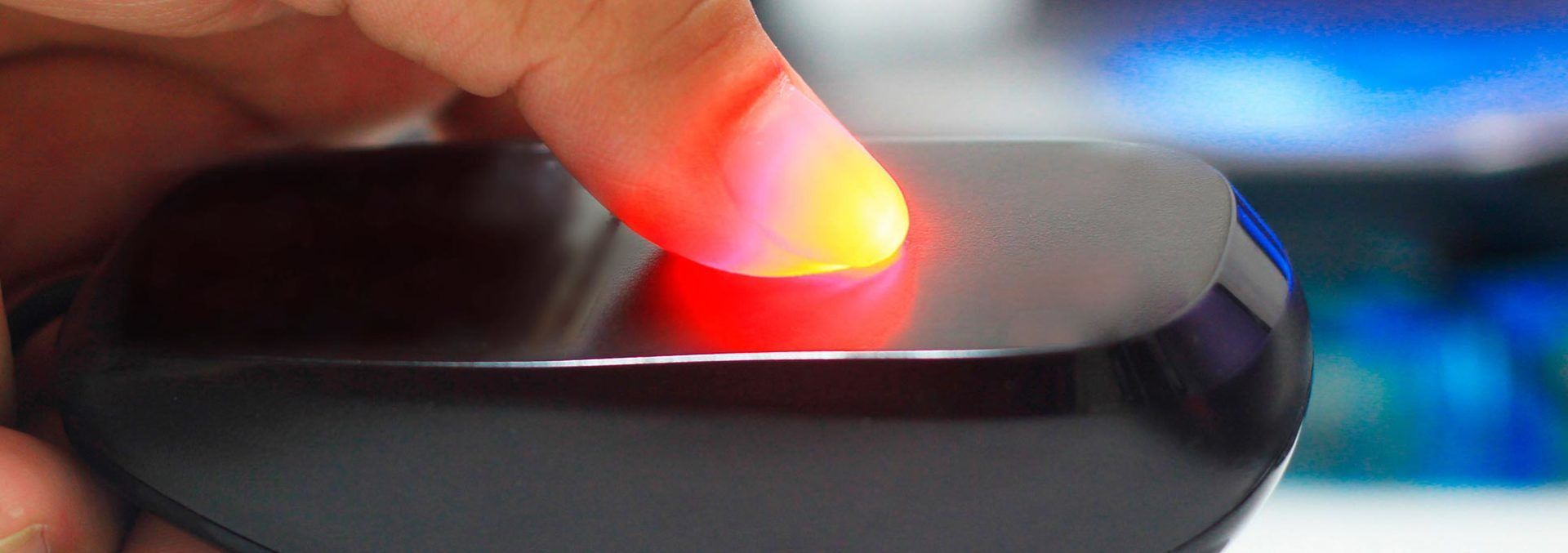 A person is holding a black object with a red light on it.