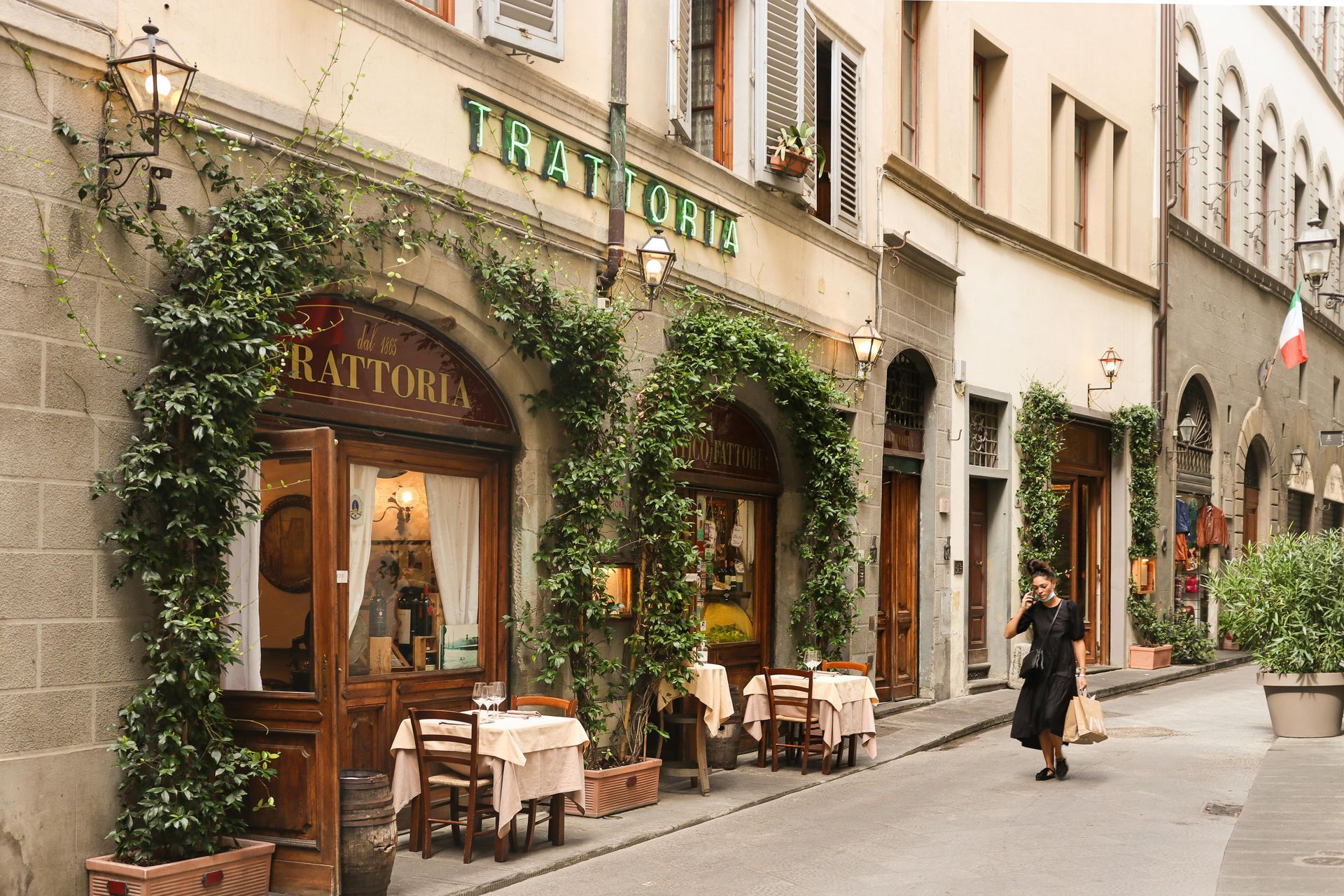 trattoria italiana en una calle con encanto con flores en la fachada