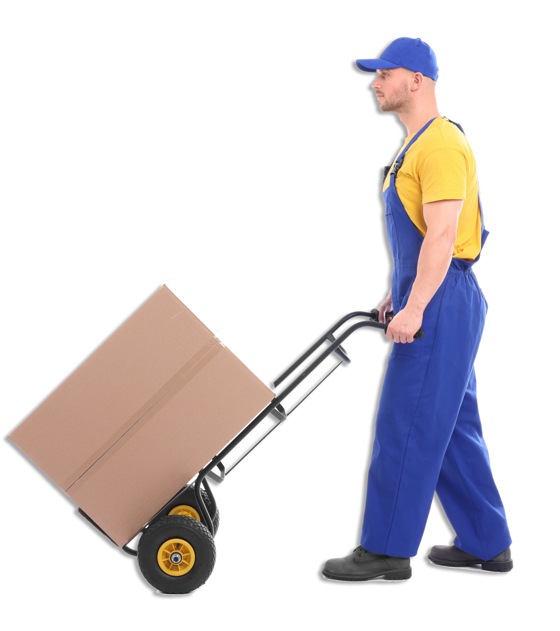 Worker in blue overalls pushing a hand truck with a large cardboard box