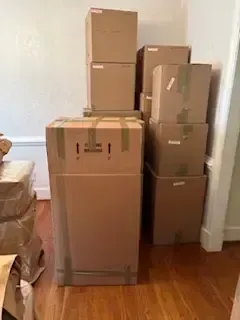 Person sealing a cardboard box with packing tape in a busy shipping area Person sealing a cardboard box with packing tape in a busy shipping area