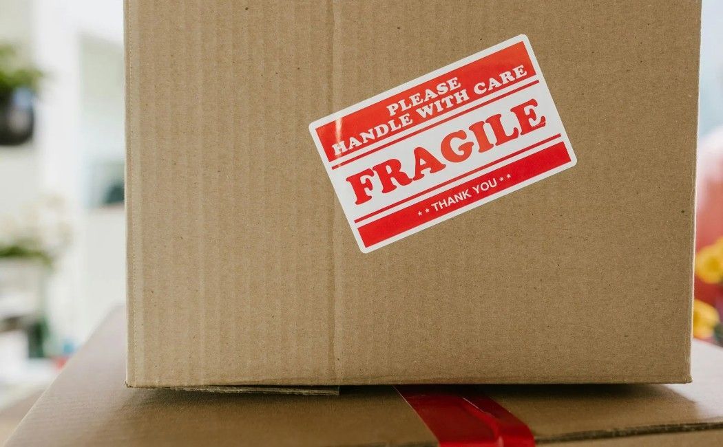Cardboard box with red fragile sticker on a package taped shut Cardboard box with red fragile sticker on a package taped shut