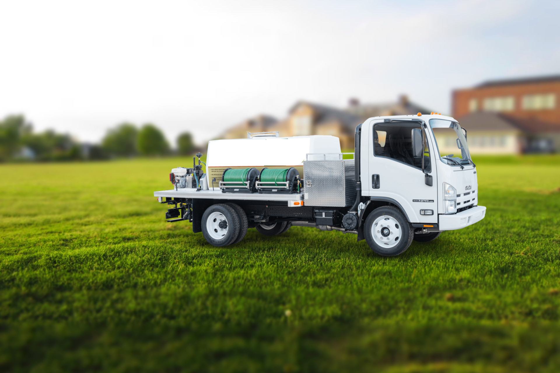 A white pest control truck is parked in a grassy field.