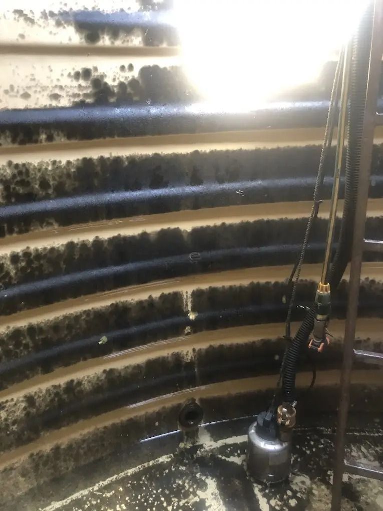 A Water Tank Filled With Green Algae And A White Pipe — Alligator Water Tank Cleaning In Pomona, QLD