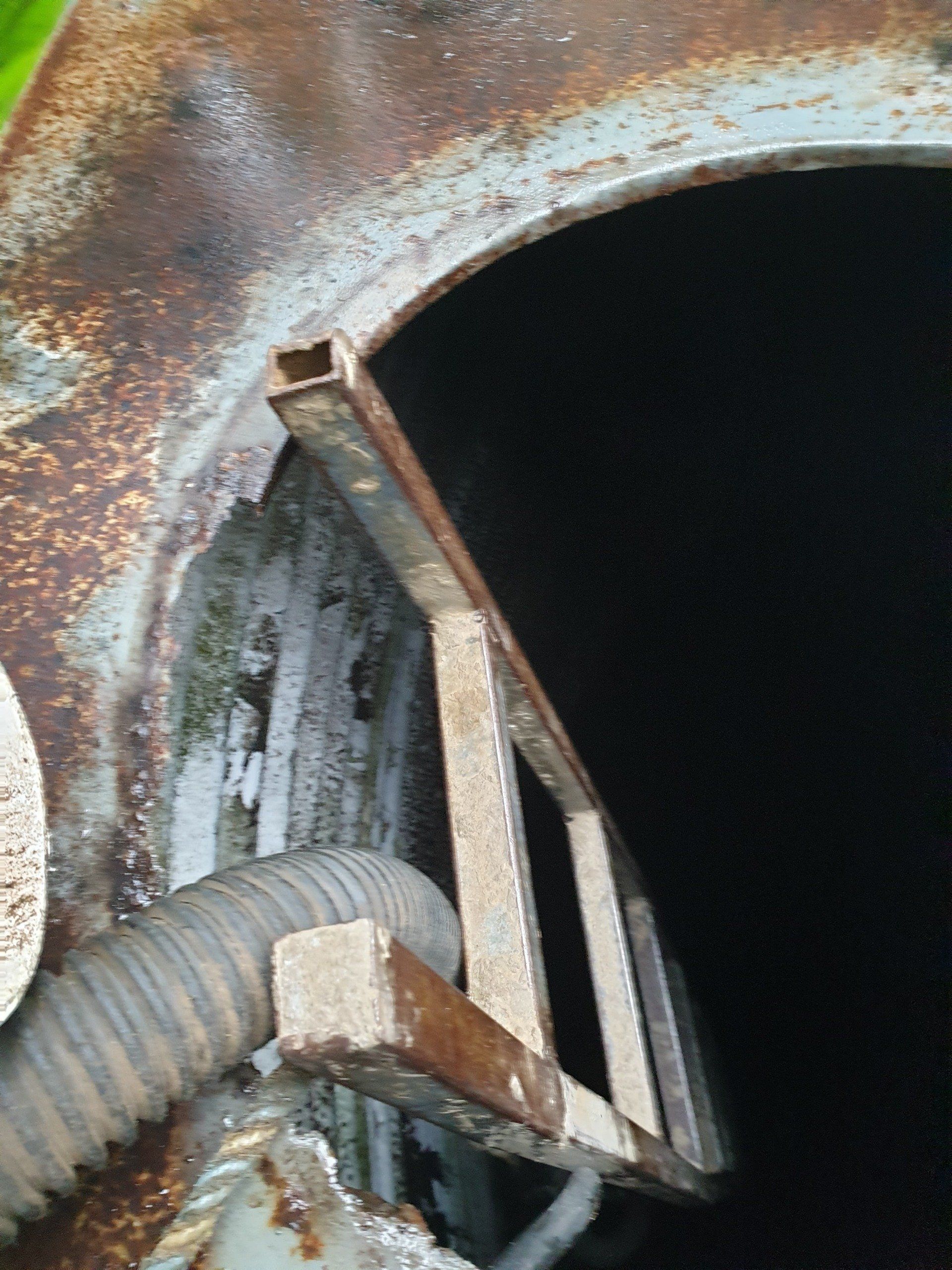 A Ladder Is Hanging From The Side Of A Rusty Metal Structure — Alligator Water Tank Cleaning In Pomona, QLD